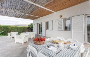 - une terrasse avec une table et un bol de fruits dans l'établissement Beautiful Home In Comiso rg With Kitchen, à Comiso