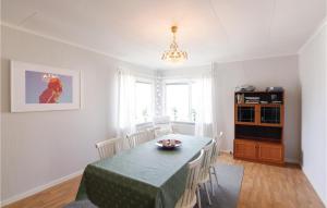 een eetkamer met een groene tafel en stoelen bij Cozy Home In Bovallstrand With House Sea View in Bovallstrand