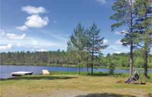 a person sitting in a chair near a lake at Lovely Home In Sandhem With Sauna in Sandhem +17 photos