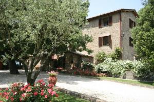 ein Gebäude mit einem Baum und Blumen davor in der Unterkunft La Locanda Della Chiocciola in Orte