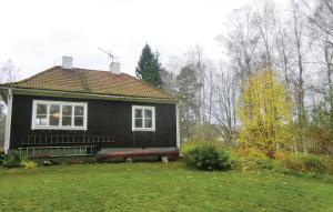 een zwart huis met een rode bank in de tuin bij Lovely Home In Storebro With Kitchen in Storebro