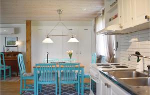 una cocina con sillas azules y una mesa con fregadero en 3 Bedroom Awesome Home In Lttorp, en Löttorp