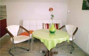 un tavolo con due sedie e un vaso con un fiore sopra di Nice Apartment In Nahetal-waldau With Wifi a Hinternah