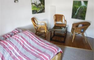a bedroom with two chairs and a bed with a striped blanket at Lovely Apartment In Linz Am Rhein in Linz am Rhein
