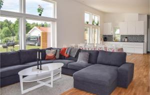 ein Wohnzimmer mit einem blauen Sofa und einem Tisch in der Unterkunft Lovely Home In Borgholm With Wifi in Folberga
