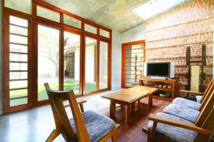 a living room with a television and a table and chairs at Chang House in Zhuangwei