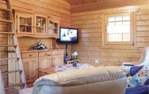 a living room with a couch and a tv in a log cabin at Nice Home In Schlitz-rimbach With Kitchen in Rimbach