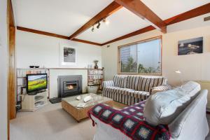 a living room with a couch and a fireplace at Herons Rise in Metung