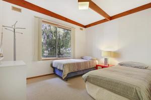 sypialnia z 2 łóżkami i oknem w obiekcie Herons Rise w mieście Metung
