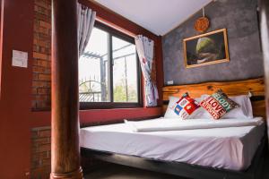 a bed in a room with a window and a bed with pillows at Vu's Homestay in Phong Nha +150 photos