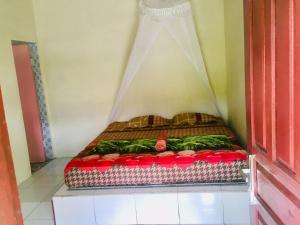 uma pequena cama num pequeno quarto com em Sahnan Guest House em Bukit Lawang