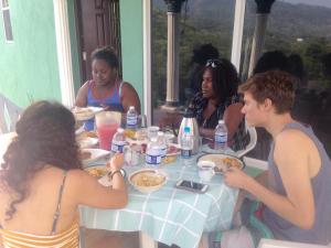 a group of people sitting around a table eating food at Haven View Villa & Spa in Bluefields