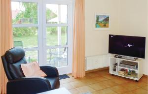 sala de estar con TV y silla en 1 Bedroom Beautiful Apartment In Kirchdorf, en Kirchdorf