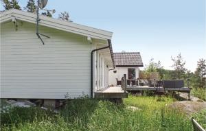 a small white house with a porch and a deck at Stunning Home In Nordre Frogn With Wifi in Båtstø