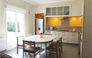 een keuken met een tafel en stoelen en een koelkast bij Stunning Home In Verquires With Wifi in Verquières