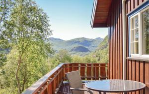 a balcony with a table and chairs and mountains at Beitebu in Hemsedal