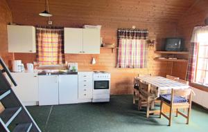 uma cozinha com uma mesa e armários brancos e uma mesa e cadeiras em Beautiful Home In Bjoa With 3 Bedrooms em Haugsgjerd