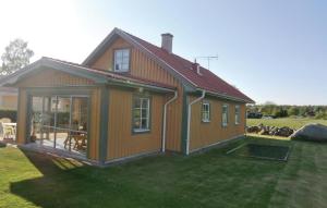 a small house with a large window on a yard at Awesome Home In Slvesborg With Kitchen in Falkvik