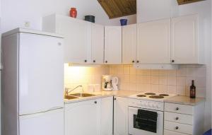 a kitchen with white cabinets and a white refrigerator at 2 Bedroom Gorgeous Home In Bolms in Bolmsö