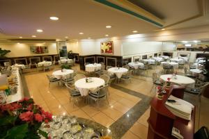 a restaurant with tables and chairs in a room at Prince Hotel in Ribeirão Preto