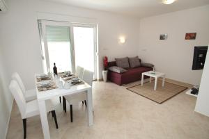 a living room with a white table and a couch at Villa Iris Apartments in Seget Vranjica