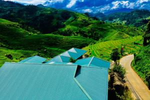 an aerial view of a farm with mountains in the background at Do Gu Homestay in Lao San Chay