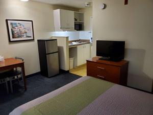 a room with a bed and a tv and a kitchen at Motel 6-Richmond, VA - I-64 West in Richmond