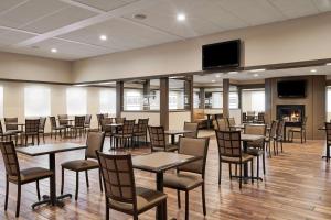 a dining room with tables and chairs and a flat screen tv at Best Western Plus Milwaukee Airport Hotel & Conference Center in Milwaukee