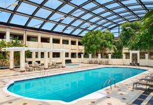 uma piscina com um telhado de vidro sobre ela em Best Western Plus Milwaukee Airport Hotel & Conference Center em Milwaukee