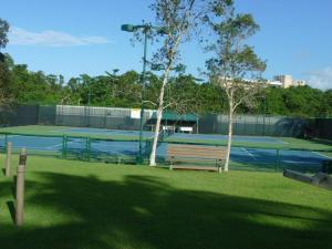 a park with a bench on a tennis court at Villa Iris 2 story ocean view villa w/ pool access in Vega Alta