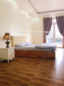 a bedroom with a bed and a dresser and a window at Thu Linh Guesthouse in Da Lat