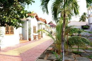 a courtyard of a house with palm trees at Ngoc Sang Guesthouse in Mui Ne