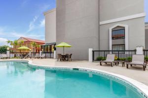 una piscina en un hotel con sillas y mesas en Sleep Inn Orangeburg en Orangeburg