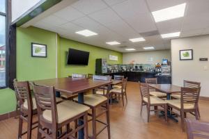 a dining room with tables and chairs and a tv at Sleep Inn Orangeburg in Orangeburg
