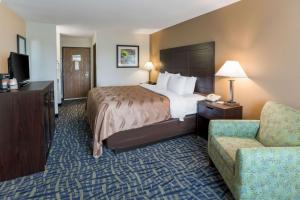 ein Hotelzimmer mit einem Bett und einem Stuhl in der Unterkunft Quality Inn Rochelle in Rochelle