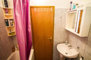 a bathroom with a wooden door and a sink at Apartment Marko - 10 m from sea in Stomorska