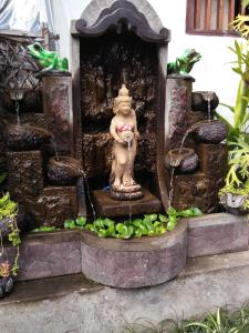 una estatua de un mono en una fuente de agua en Wirya House, en Ubud