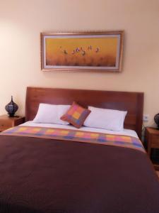 een slaapkamer met een bed met een foto aan de muur bij Wirya House in Ubud