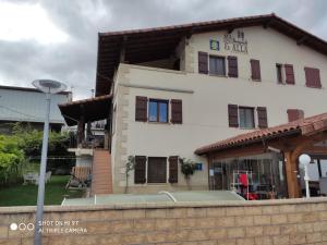 un edificio blanco con una valla delante en Alojamientos Acá y Allá, en Urdániz