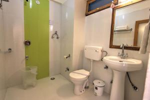 a bathroom with a toilet and a sink and a shower at Hotel Mountain face by Snow City Hotels in Manāli