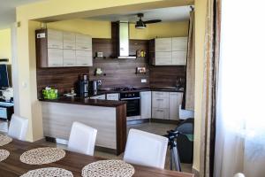 a kitchen with white cabinets and a table and chairs at Synergy House in Dudince