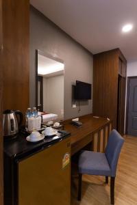a kitchen with a table and a chair in a room at Lima Lanna Hotel in Chiang Mai