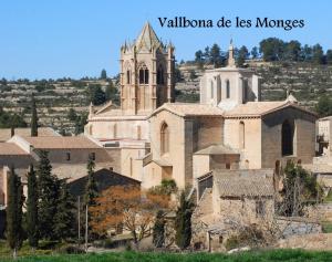 una gran iglesia con una torre y un campanario en Cal Baster, en Vallbona de les Monges
