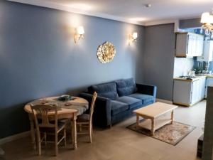 a living room with a blue couch and a table at Luxury Studio Anis 1 in Mamaia Sat/Năvodari