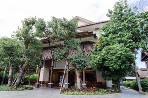 a building with trees in front of it at Lima Lanna Hotel in Chiang Mai