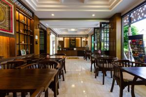 a dining room with wooden tables and chairs at Lima Lanna Hotel in Chiang Mai
