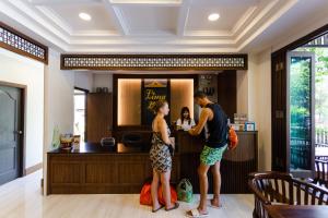 a man and a woman standing at a bar at Lima Lanna Hotel in Chiang Mai