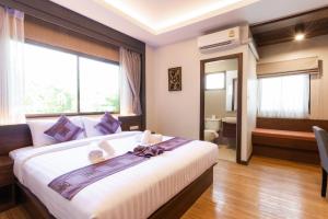 a hotel room with a large bed and a bathroom at Lima Lanna Hotel in Chiang Mai +60 photos