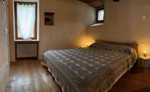 ein Schlafzimmer mit einem Bett und zwei Fenstern in der Unterkunft Casa Pietra in Trontano