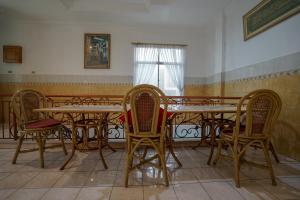 une salle à manger avec des tables et des chaises ainsi qu'une fenêtre dans l'établissement SUPER OYO 1173 Hotel Shofa Marwah, à Palembang